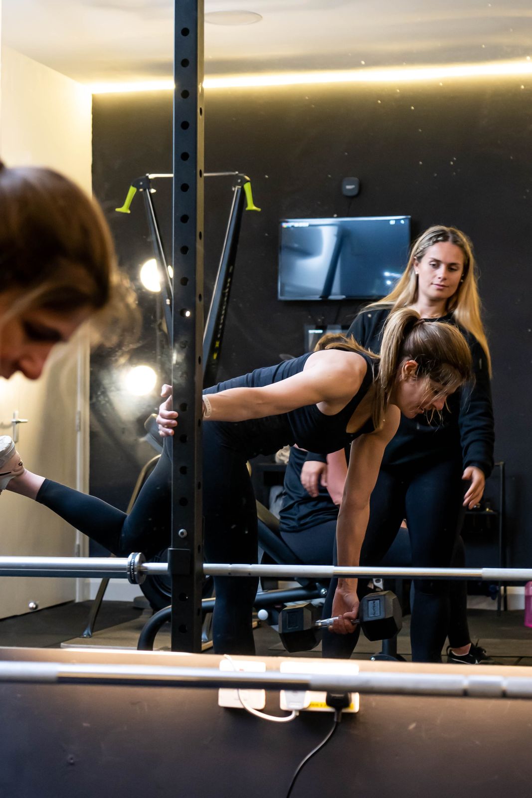 A coach cueing a member through a deadlift