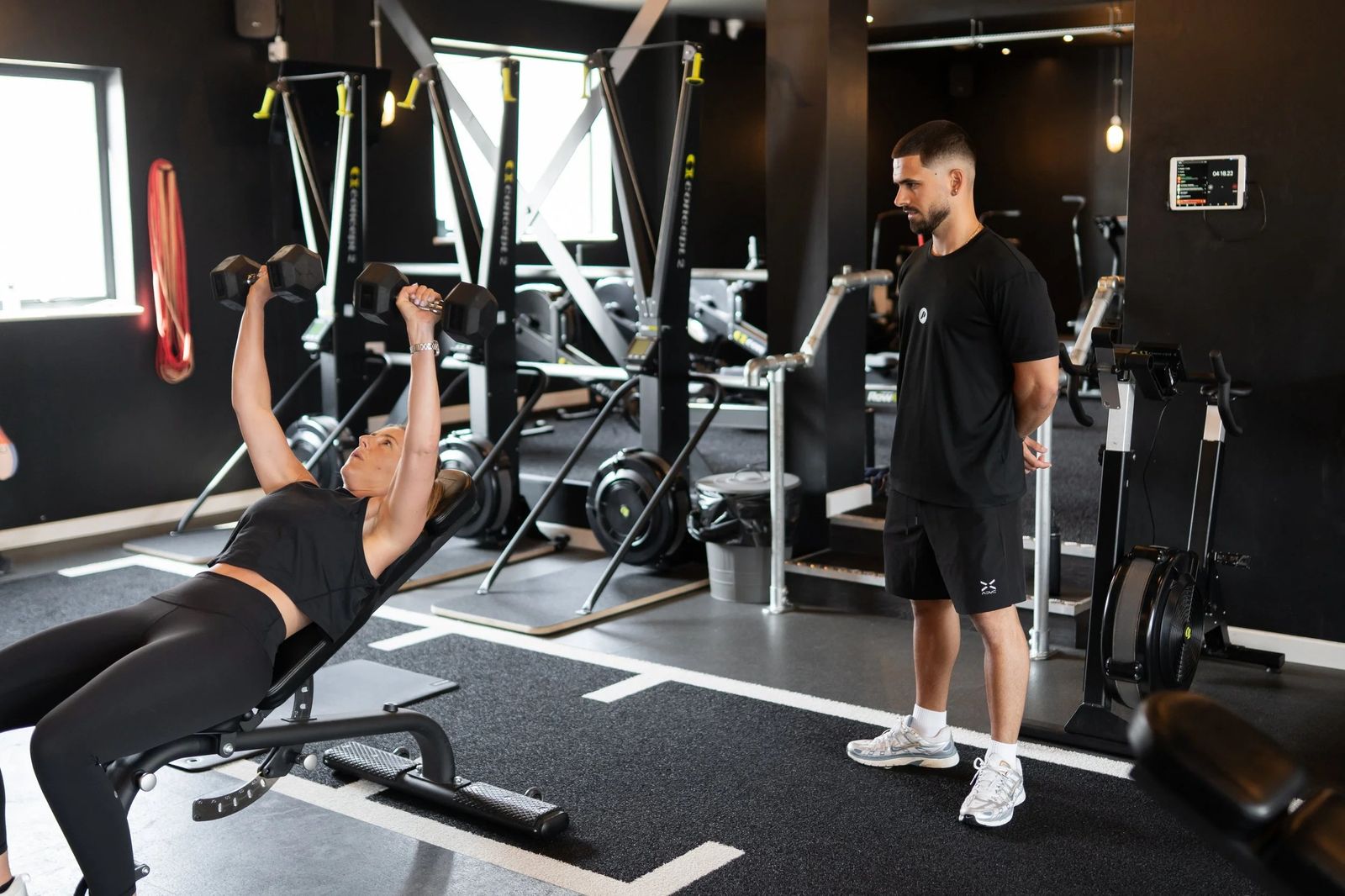 An incline press, a coach watching the form.