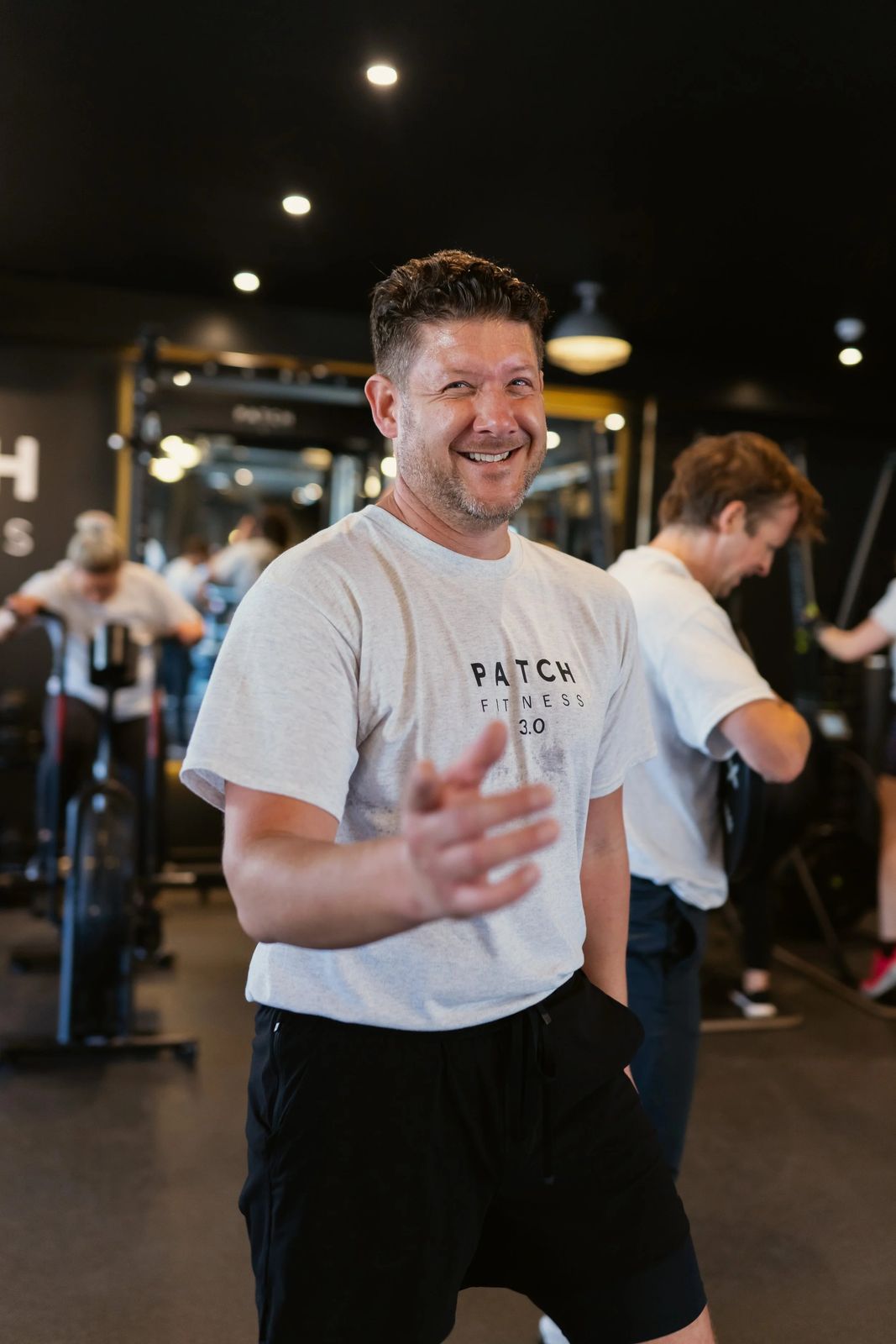 A Patch coach laughing with members on the gym floor